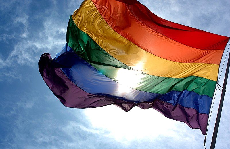 Bandera arcoiris contra cielo azul